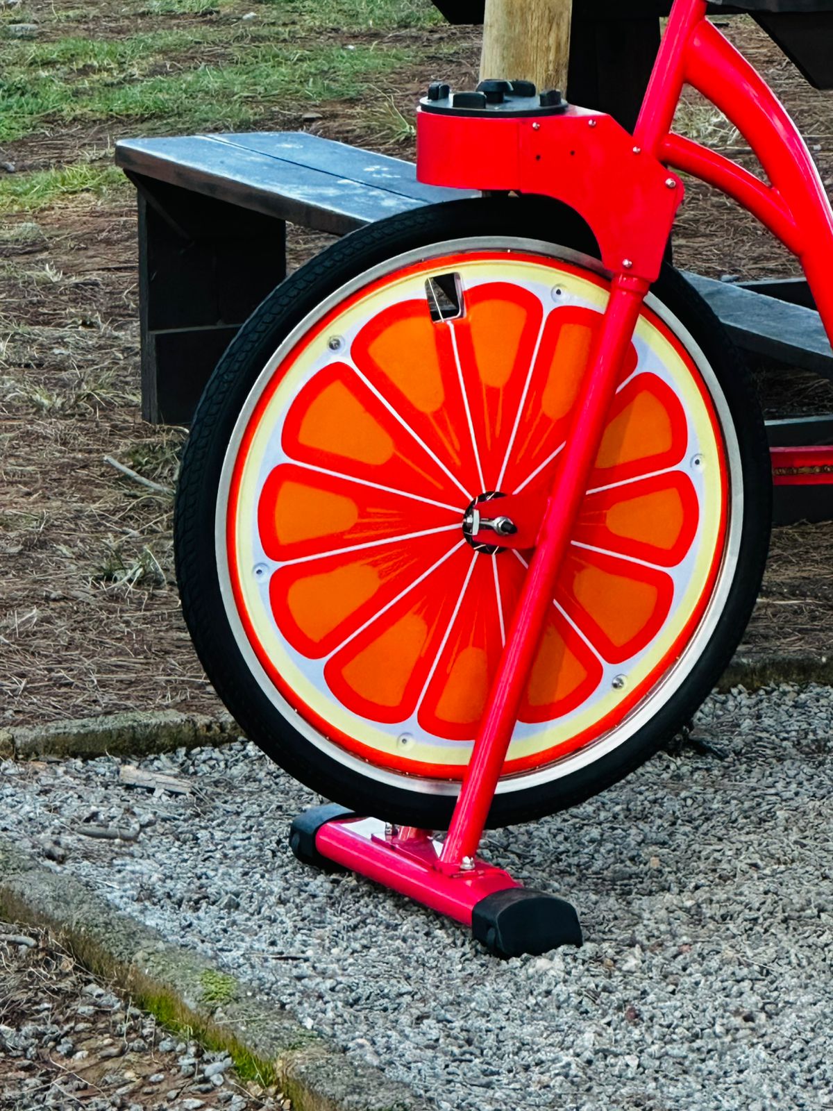 Close-up of a red smoothie bike with bright orange-slice wheel